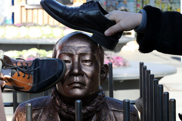 신군부가 일으킨 12·12 군사반란 40주년인 12일 5·18 관련 단체 회원들이 서울 광화문광장에서 전두환 전 대통령의 구속 수사를 촉구하는 기자회견을 한 뒤 이를 상징적으로 표현하기 위해 제작한 동상 조형물을 때리는 퍼포먼스를 하고 있다. 2019.12.12  연합뉴스