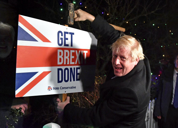 보리스 존슨 영국 총리가 조기 총선 전날인 11일(현지시간) 런던 동쪽 벤플리트에 있는 한 지지자의 정원에 ‘브렉시트를 완수하자’고 적힌 팻말을 박고 있다. 벤플리트 AP 연합뉴스