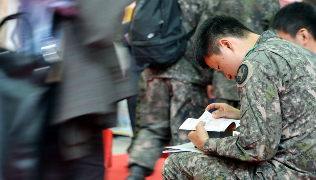 취업박람회를 찾은 군인이 기업 소개책자를 읽고 있는 모습. 서울신문 DB