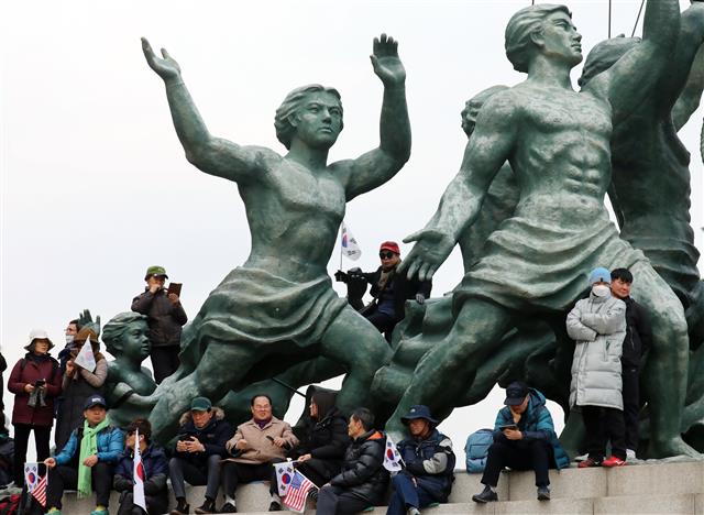 국회 동상에 올라가 집회하는 보수단체 회원들