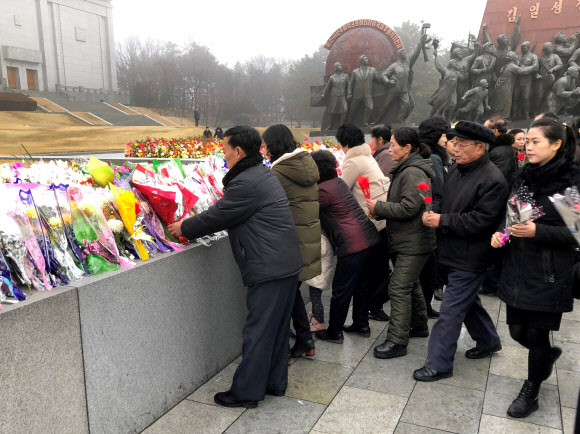 북한 주민들이 17일(현지시간) 김정일 국방위원장의 사망 8주기를 맞아 평양 만수대언덕 김일성과 김정일 동상에 헌화하고 있다. 타스 연합뉴스
