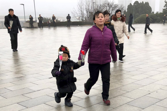 북한 주민들이 17일(현지시간) 김정일 국방위원장의 사망 8주기를 맞아 평양 만수대언덕 김일성과 김정일 동상에 헌화하고 있다. 타스 연합뉴스