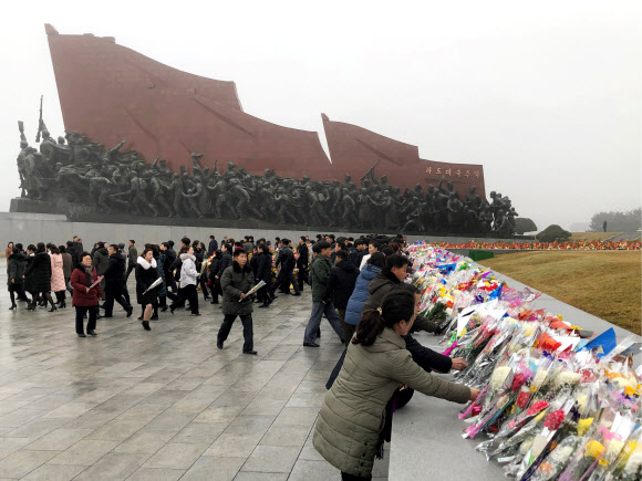 북한 주민들이 17일(현지시간) 김정일 국방위원장의 사망 8주기를 맞아 평양 만수대언덕 김일성과 김정일 동상에 헌화하고 있다. 타스 연합뉴스