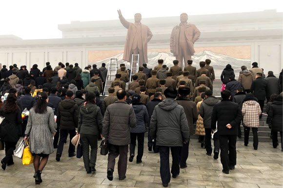 북한 주민들이 17일(현지시간) 김정일 국방위원장의 사망 8주기를 맞아 평양 만수대언덕 김일성과 김정일 동상으로 향하고 있다. 타스 연합뉴스