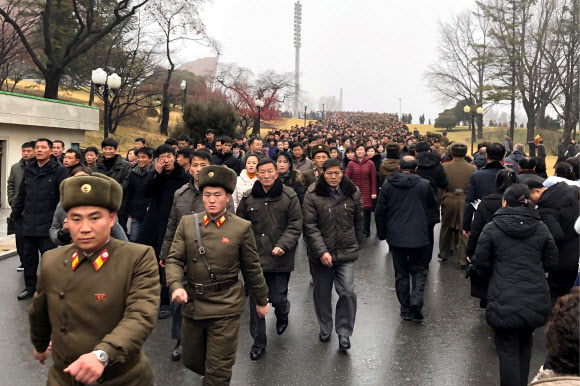 북한 주민들이 17일(현지시간) 김정일 국방위원장의 사망 8주기를 맞아 평양 만수대언덕 김일성과 김정일 동상으로 향하고 있다. 타스 연합뉴스