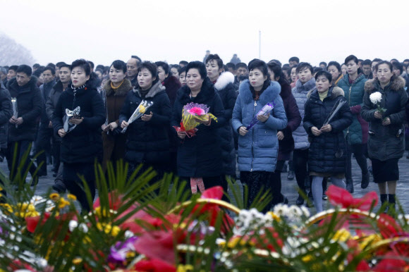 북한 주민들이 17일(현지시간) 김정일 국방위원장의 사망 8주기를 맞아 평양 만수대언덕 김일성과 김정일 동상에 헌화하고 있다. AP 연합뉴스