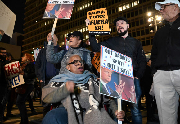 도널드 트럼프 미국 대통령에 대한 하원 탄핵소추안 표결을 하루 앞둔 17일(현지시간) 미국 캘리포니아주 로스앤젤레스에서 탄핵을 지지하는 시위대가 시위를 벌이고 있다. AFP 연합뉴스