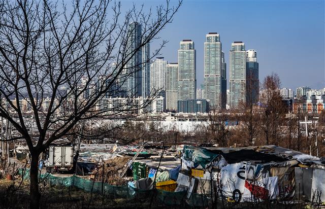 서울 강남구 구룡마을과 그 너머로 보이는 양재천변의 초고층 아파트숲.구룡마을에서는 개발을 둘러싸고 주민 간 갈등이 빚어지고 있다.