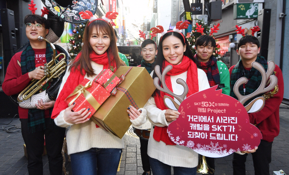 19일 서울 명동예술극장 앞에서 ‘SK텔레콤 캐럴 이즈 백’ 행사에서 모델들이 포즈를 취하고 있다. 이 행사는 이달 21부터 한 달 동안 전국 자영업자들에게 크리스마스 캐럴 등이 포함된 스트리밍 서비스를 무료로 제공하는 프로젝트다. 2019.12.19 오장환 기자 5zzang@seoul.co.kr