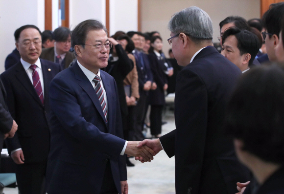 문재인 대통령이 19일 청와대에서 열린 확대경제장관회의에서 홍남기 경제부총리와 입장하며 참석자들과 인사를 나누고  있다. 2019. 12.19 도준석 기자pado@seoul.co.kr