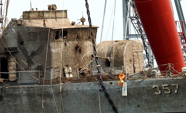 2002년 6월 29일 제2연평해전으로 침몰된 참수리 고속정 357호정이 같은 해 8월 21일 해저에서 인양돼 옮겨지고 있다. 군은 펄로 뒤덮인 함정을 생존대원에게 직접 청소하라고 지시했다. 사진공동취재단