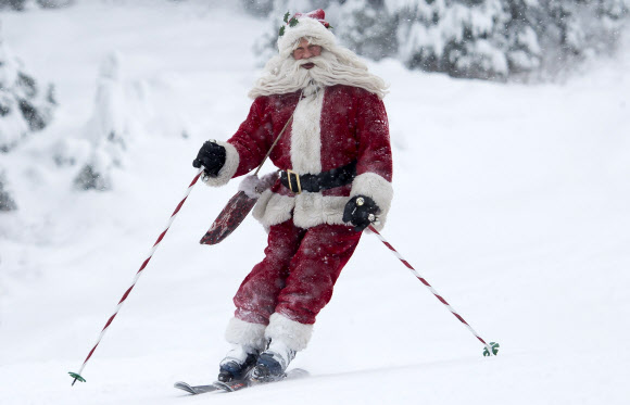 산타 클로스 복장을 한 남성이 20일(현지시간) 캐나다 브리티시 컬럼비아 휘슬러에서 산타 스키를 타고 있다. AP 연합뉴스