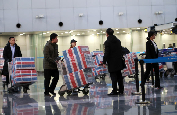 북한 해외 노동장 송환 시한을 하루 앞둔 22일 중국 베이징 서우두 공항에서 북한 노동자로 추정되는 사람들이 귀국 준비를 하고 있다. 2019.12.21  연합뉴스