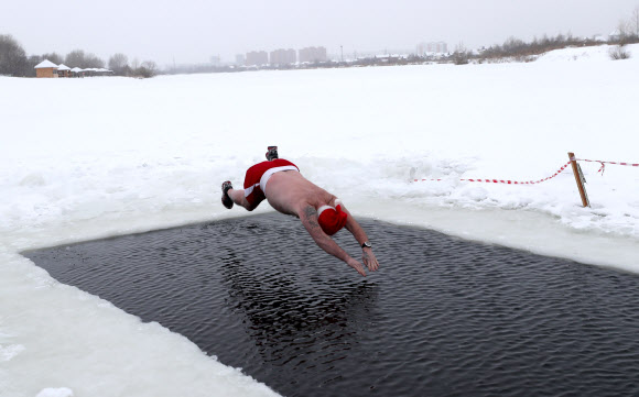 20일(현지시간) 러시아 노보시비르스크 겨울 수영 클럽 회원이 프로스트 신부 의상을 입고 수영을 즐기고 있다. 타스 연합뉴스