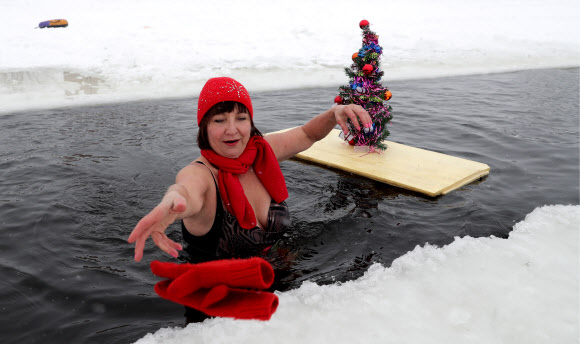 20일(현지시간) 러시아 노보시비르스크 겨울 수영 클럽 회원이 동화 ‘빨간 모자’ 의상을 입고 수영을 즐기고 있다. 타스 연합뉴스