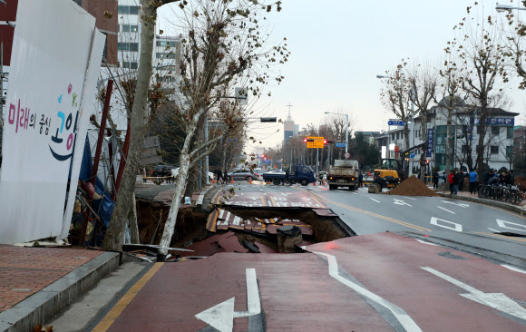 21일 경기도 고양시 일산동구 백석동 신축공사 현장 옆 도로에서 ‘땅 꺼짐’ 현상이 발생, 경찰이 도로를 통제하고 있다.     2019.12.21  연합뉴스