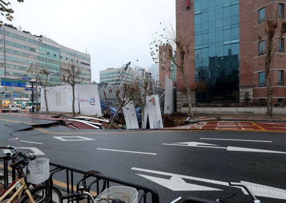 21일 경기도 고양시 일산동구 백석동 신축공사 현장 옆 도로에서 ‘땅 꺼짐’ 현상이 발생, 경찰이 도로를 통제하고 있다.     2019.12.21  연합뉴스