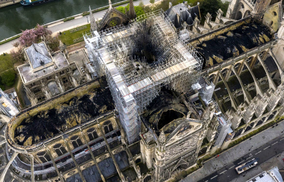 지난 4월 15일 화재로 850여년 역사의 프랑스 파리 노트르담 대성당이 훼손된 현장. 화재 다음날 촬영된 파노라마 사진에 96m 높이 첨탑과 목재 지붕이 불에 타 무너져 내린 자리가 연기에 검게 그을려 있다. 파리 AP 연합뉴스