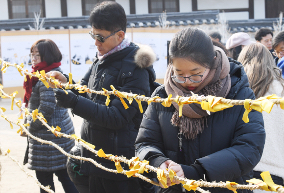 24절기 중 밤의 길이가 가장 길다는 동지인 22일 오전 서울 중구 남산골한옥마을에서 열린 ‘작은 설 동지 행사’에서 한 어린이가 줄에 소원지를 매듭지어 걸고 있다. 2019. 12.22 김명국 선임기자 daunso@seoul.co.kr