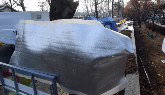 서울시가 지난 20일 청와대 앞에서 석달 째 점거농성 중인 ‘문재인하야 범국민투쟁본부’측에 22일까지 불법 시설물을 철거해달라는 내용의 행정대집행 계고장을 보낸 가운데 22일 청와대 앞 농성장에서 범투본측 관계자들이 기자들의 취재를 막고 있다. 2019. 12. 22 정연호 기자 tpgod@seoul.co.kr