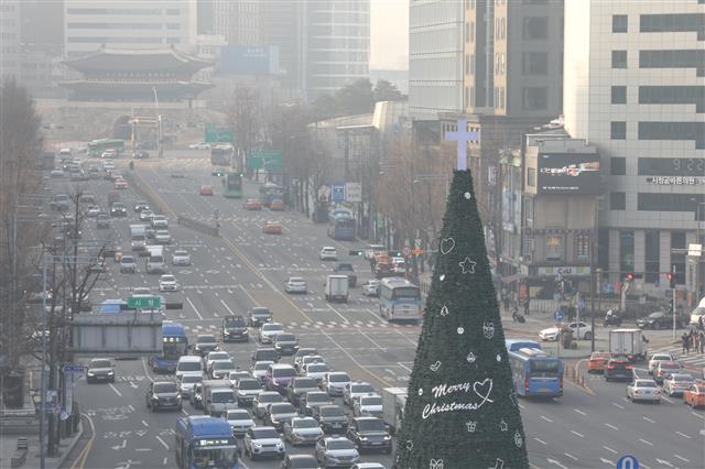 수도권 등 권역에 미세먼지 농도가 ‘나쁨’ 수준을 보이고 있는 24일 오전 서울 시청 앞 광장에 설치된 성탄트리 뒤로 서울 도심이 뿌옇게 보이고 있다.  국립환경과학원은 이날 대기 정체로 국내 발생 미세먼지와 전일 유입된 국외 미세먼지가 축적돼 중서부지역과 일부 영남내륙지역에서 농도가 높을 것으로 전망했다. 2019.12.24 뉴스1