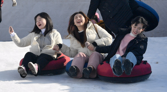 뚝섬 눈썰매장이 개장을 한 24일 서울 뚝섬 눈썰매장에서 시민들이 즐거운 표정으로 눈썰매를 즐기고 있다. 2019.12.24 박지환기자 popocar@seoul.co.kr
