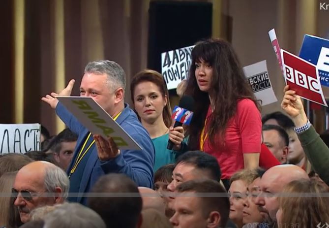 알리샤 야로프스카야 기자가 지난 19일 블라디미르 푸틴 러시아 대통령의 연례 기자회견 때 마이크를 가로채 발언하자 앞의 지목을 받은 기자가 두 팔을 벌려 어이없다는 동작을 취하고 있다. BBC 동영상 캡처 