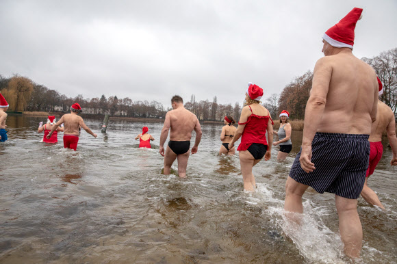 ‘Berliner Seehunde’수영 클럽 멤버들이 25일(현지시간) 독일 베를린의 오랑케세 호수에서 전통적인 크리스마스 겨울 수영에 참가하고 있다. EPA 연합뉴스