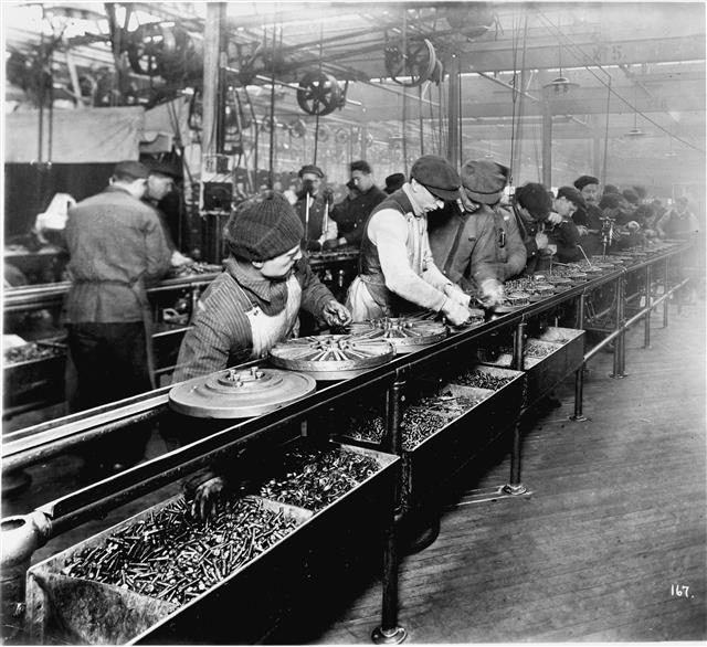 1913년 미국 디트로이트에 있는 포드 하이랜드파크 공장의 조립 라인 노동자들이 줄지어 자동차 바퀴 나사를 조이고 있다. 포드는 자동차회사 최초로 조립 라인 방식을 도입하면서 대량생산 체제를 구축했다.  시공사 제공