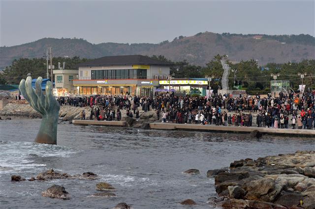 29일 경북 포항시 남구 호미곶해맞이 광장에서 관광객들이 상생의 손 뒷편으로 떠오르는 을미년 마지막 태양을 바라보고 있다. 2019.12.29 뉴스1