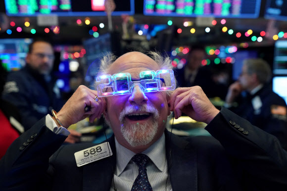 미국 뉴욕 증권거래소(NYSE)의 명물 트레이더 피터 터크먼이 31일(현지시간) 2020 색안경을 쓴 채 2020년 증시에 대한 희망을 담아내고 있다. 뉴욕 로이터 연합뉴스 