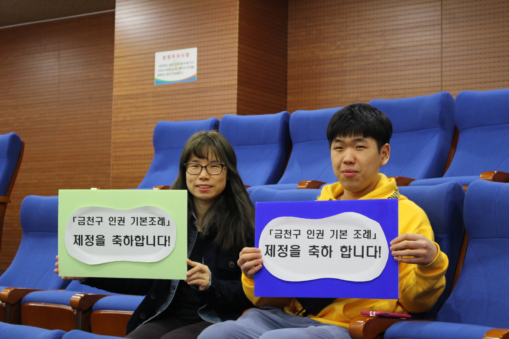 금천구의회 본회의에서 주민들이 ‘금천구 인권 기본 조례안’ 제정을 축하하는 피켓을 들고 있는 모습