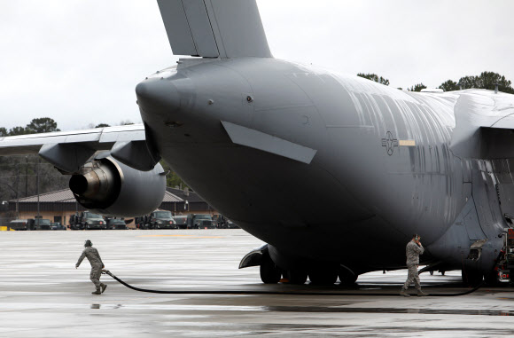 Ground crewmen work near a U.S. Air Force C-17 plane as it is readied to transport U.S. Army paratroopers from the 2nd Battalion, 504th Parachute Infantry Regiment, 1st Brigade Combat Team, 82nd Airborne Division, to the Middle East from Fort Bragg, North Carolina, U.S. January 4, 2020.  REUTERS=연합뉴스