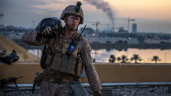 지난 4일(현지시간) 이라크 바그다드의 미국 대사관을 경계하는 해병대 병사가 참호를 보강하기 위해 모래주머니를 옮기고 있다. 뒤쪽에 포연이 보인다. 미군 해병대 제공 AP 연합뉴스 