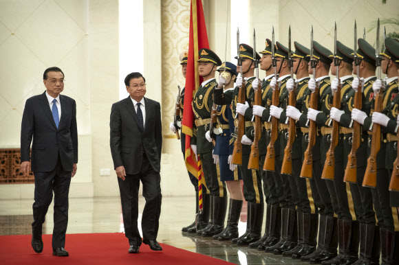 리커창(왼쪽) 중국 총리와 통룬 시슬리트(가운데) 라오스 총리가 6일(현지시간) 중국 베이징의 인민대회당에서 의장대를 사열하고 있다. AP 연합뉴스