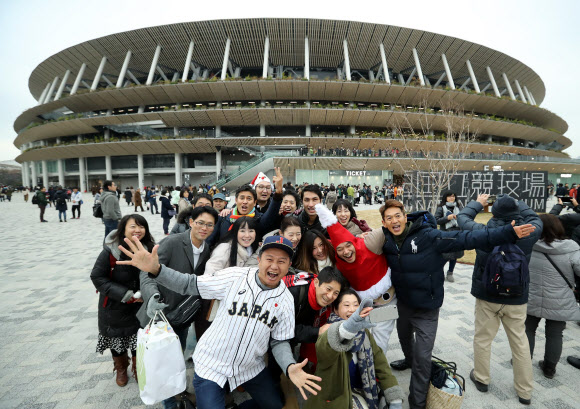 도쿄 시민들이 신국립경기장 개장 행사가 열린 지난해 12월 21일 경기장 앞에서 즐거운 모습으로 기념촬영을 하고 있다. 서울신문 DB