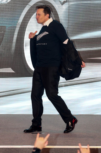 일런 머스크 테슬라 최고경영자가 7일 중국 상하이 기가팩토리에서 열린 중국산 모델3 인도행사에서 양복 상의를 벗으며 막춤을 추고 있다. 상하이 AFP 연합뉴스
