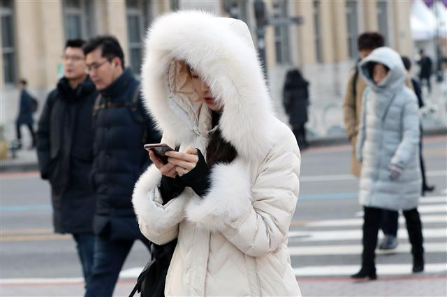 전국에 내리던 비가 그치면서 다시 한파가 시작된 9일 오전 서울 광화문네거리에서 시민들이 출근길 발걸음을 재촉하고 있다. 기상청 관계자는 “8일 밤부터 북서쪽에서 찬 공기가 유입돼 9일 아침은 매우 춥겠으니 건강관리에 유의해야 한다”면서 “곳곳에서 그간 내린 비가 얼어 지표면이 미끄럽겠으니 교통 안전에 주의를 기울이기 바란다”고 당부했다. 2020.1.9 뉴스1