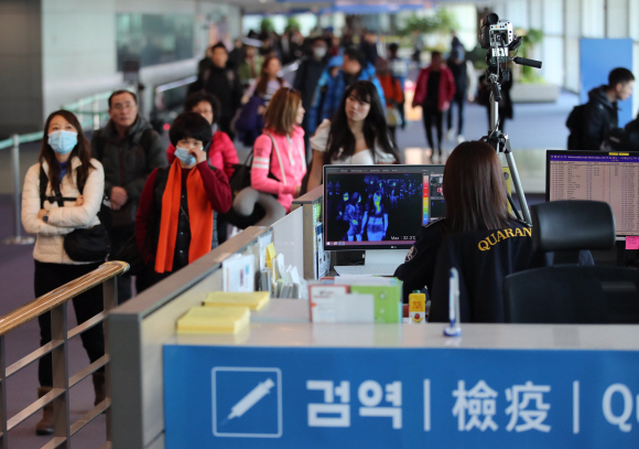 9일 인천국제공항 제1터미널 입국장에서 질병관리본부 국립검역소 직원들이 열화상 카메라로 중국 공항에서 출발해 인천공항에 도착한 승객들의 체온을 측정하고 있다. 질병관리본부에 따르면 중국에서 집단으로 발생한 원인불명 폐렴과 관련해 국내에서 관련 증상을 보인 환자 1명이 발생했다. 2020. 1.9  박윤슬 기자 seul@seoul.co.kr