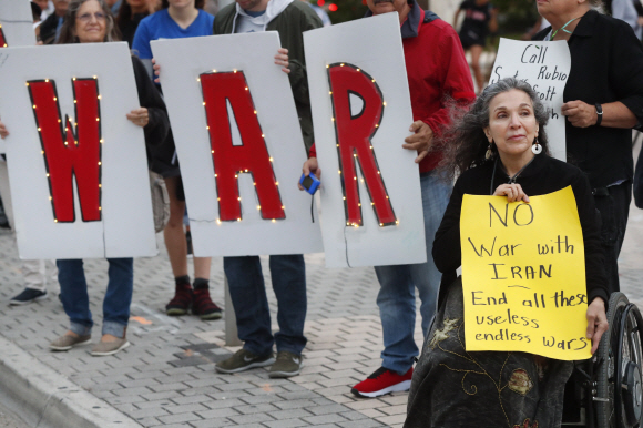 Nadina Laspina, right, joins other anti-war demonstrator as they hold signs for passing cars at the Torch of Friendship monument, Thursday, Jan. 9, 2020, in Miami. (AP Photo/Wilfredo Lee)/2020-01-10 09:39:41/ <저작권자 ⓒ 1980-2020 ㈜연합뉴스. 무단 전재 재배포 금지.>