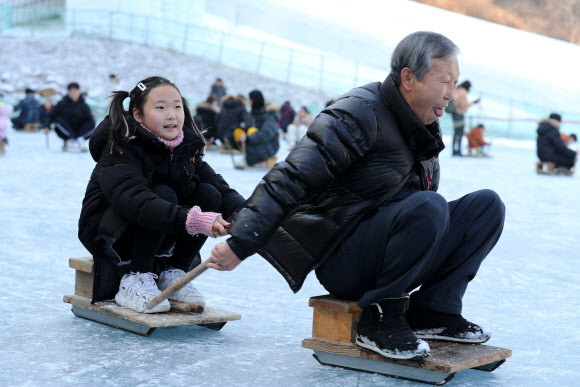 10일 오후 충남 청양군에 있는 알프스마을, 칠갑산 얼음분수축제를 찾은 할아버지와 손녀가 설매를 타며 즐거운 시간을 보내고 있다. 2020.1.10  연합뉴스