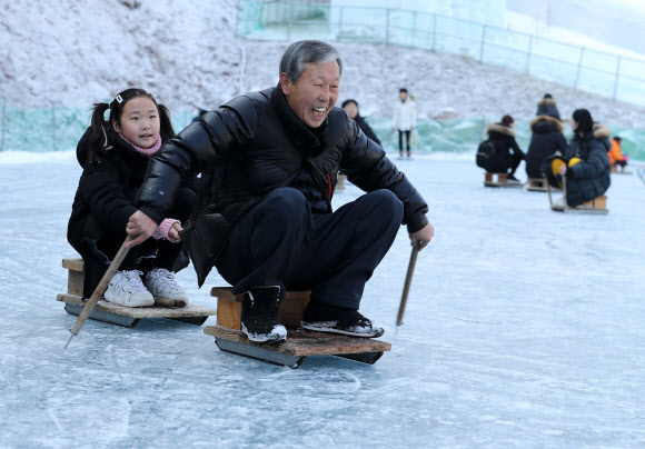 10일 오후 충남 청양군에 있는 알프스마을, 칠갑산 얼음분수축제를 찾은 할아버지와 손녀가 설매를 타며 즐거운 시간을 보내고 있다. 2020.1.10  연합뉴스