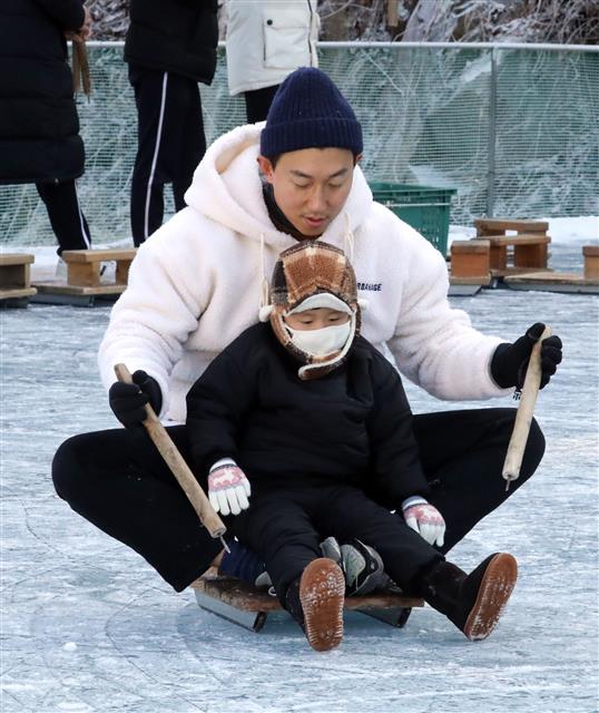 10일 충남 청양군 알프스마을에서 열리고 있는 칠갑산 얼음분수 축제에서 아이가 아버지 발 위에 앉은 채 전통썰매를 타고 있다. 2020.1.10 뉴스1