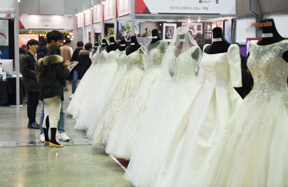 12일 서울 강남 코엑스 B홀에서 열린 2020 춘계 웨덱스코리아 웨딩박람회에서 예비 신랑, 신부들이 전시되어 있는 웨딩드레스를 살펴보고 있다. 2020.1.12 오장환 기자 5zzang@seoul.co.kr