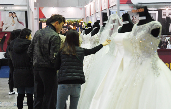 12일 서울 강남 코엑스 B홀에서 열린 2020 춘계 웨덱스코리아 웨딩박람회에서 예비 신랑, 신부들이 전시되어 있는 웨딩드레스를 살펴보고 있다. 2020.1.12 오장환 기자 5zzang@seoul.co.kr