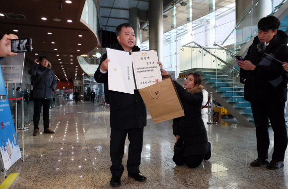자유한국당 추천으로 ‘가습기 살균제 참사와 4·16 세월호 참사 특별조사위원회’(특조위) 비상임위원에 임명된 김기수 변호사가 13일 오전 서울 중구 포스트타워 특조위 운영지원과에 사퇴서를 제출하기에 앞서 임명장을 취재진에게 들어보이고 있다. 2020. 1.13  박윤슬 기자 seul@seoul.co.kr
