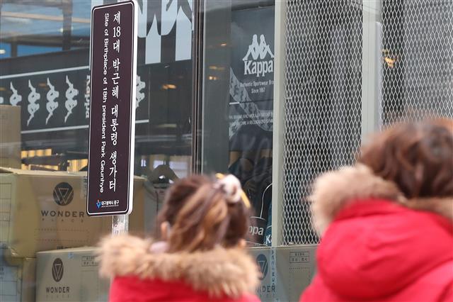 13일 대구 중구 삼덕동 박근혜 전 대통령 생가터(현 쇼핑몰 건물) 옆에 ‘제18대 박근혜 대통령 생가터’라고 적힌 표지판이 재설치돼 있다.  최초 박 전 대통령 생가터에 설치된 표지판은 지난 2013년 2월25일 중구청이 박 대통령의 취임을 기념해 설치했었다. 당시 박 대통령이 꽃다발을 들고 손을 흔드는 모습이었다.  그러나 2016년 11월18일 최순실 국정농단 사태에 불만을 품은 50대 남성이 붉은색 스프레이를 뿌리는 등 훼손돼 철거됐다가 한 시민단체의 지속적인 재설치 요구를 중구청이 받아들여 2019년 10월 다시 세워진 것으로 알려졌다. 2020.1.13 뉴스1