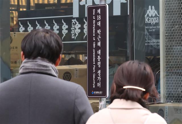 13일 대구 중구 삼덕동 박근혜 전 대통령 생가터(현 쇼핑몰 건물) 옆에 ‘제18대 박근혜 대통령 생가터’라고 적힌 표지판이 재설치돼 있다.  최초 박 전 대통령 생가터에 설치된 표지판은 지난 2013년 2월25일 중구청이 박 대통령의 취임을 기념해 설치했었다. 당시 박 대통령이 꽃다발을 들고 손을 흔드는 모습이었다.  그러나 2016년 11월18일 최순실 국정농단 사태에 불만을 품은 50대 남성이 붉은색 스프레이를 뿌리는 등 훼손돼 철거됐다가 한 시민단체의 지속적인 재설치 요구를 중구청이 받아들여 2019년 10월 다시 세워진 것으로 알려졌다. 2020.1.13 뉴스1