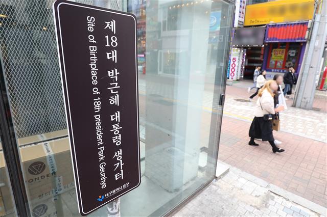 13일 대구 중구 삼덕동 박근혜 전 대통령 생가터(현 쇼핑몰 건물) 옆에 ‘제18대 박근혜 대통령 생가터’라고 적힌 표지판이 재설치돼 있다.  최초 박 전 대통령 생가터에 설치된 표지판은 지난 2013년 2월25일 중구청이 박 대통령의 취임을 기념해 설치했었다. 당시 박 대통령이 꽃다발을 들고 손을 흔드는 모습이었다.  그러나 2016년 11월18일 최순실 국정농단 사태에 불만을 품은 50대 남성이 붉은색 스프레이를 뿌리는 등 훼손돼 철거됐다가 한 시민단체의 지속적인 재설치 요구를 중구청이 받아들여 2019년 10월 다시 세워진 것으로 알려졌다. 2020.1.13 뉴스1