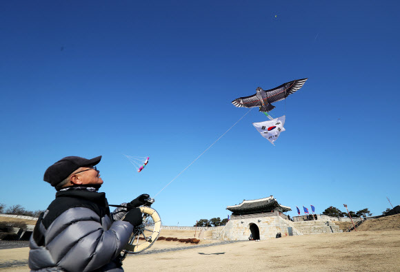미세먼지가 물러가며 맑은 날씨를 보인 13일 오후 경기도 수원시 세계문화유산 화성(華城) 창룡문에서 한국연연맹 수원지회 회원들이 연을 날리고 있다. 2020.1.13  연합뉴스